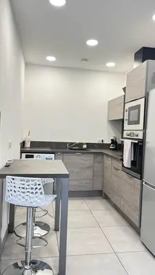 a kitchen with a table and a refrigerator at N9 Maison T2 climatisé in Ajaccio