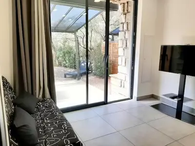 a living room with a couch and a sliding glass door at N9 Maison T2 climatisé in Ajaccio
