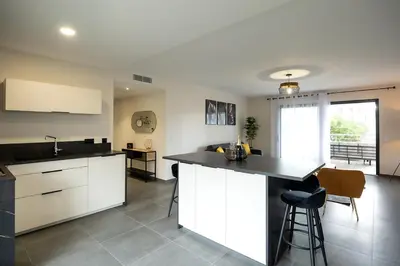 a kitchen with white cabinets and a black counter top at Domaine d'Arca - Flaubert 13 - 6 pers in Porto-Vecchio