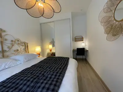 a bedroom with a large bed and two chandeliers at Appartement de charme à Propriano, vue sur le Golfe in Viggianello