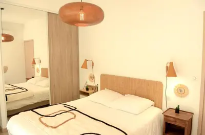a bedroom with two beds and a mirror at Appartement de charme à Propriano, vue sur le Golfe in Viggianello