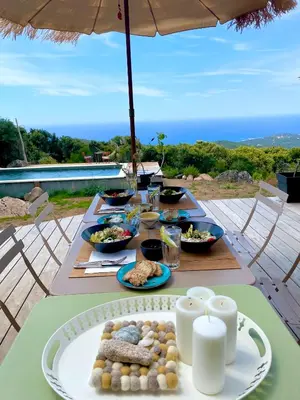 a table with plates of food on a table with an umbrella at Casa Altura in Coti-Chiavari