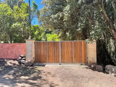 a fence with a wooden gate in a yard at Casa Altura in Coti-Chiavari