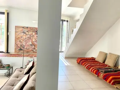 a couch sitting in a living room under a staircase at Casa Altura in Coti-Chiavari