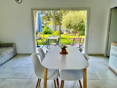 a white dining room with a white table and chairs at Mini Villa Pascal Paoli avec piscine - proche mer in Prunelli-di-Fiumorbo