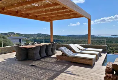 a deck with chairs and a table and a view at Schena Villata in Zonza