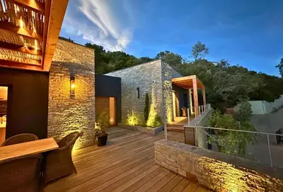 a house with a wooden deck with a building at Schena Villata in Zonza