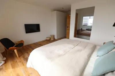 a bedroom with a large white bed and a mirror at Schena Villata in Zonza