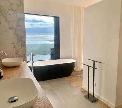 a bathroom with a bath tub and a large window at Schena Villata in Zonza