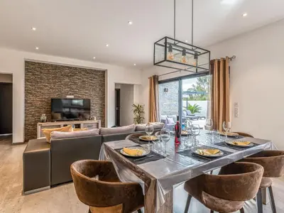 a kitchen with white cabinets and a flat screen tv at Holiday Home Villa les lieges by Interhome in Lecci