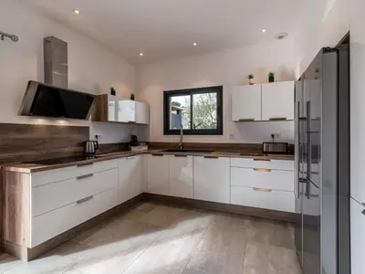 a kitchen with white cabinets and a stainless steel refrigerator at Holiday Home Villa les lieges by Interhome in Lecci