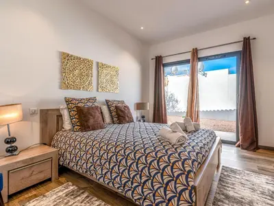 a bedroom with a bed and a large window at Holiday Home Villa les lieges by Interhome in Lecci