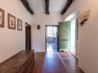 a hallway with a wooden bench and a green door at Holiday Home Maison Penta by Interhome in Penta-di-Casinca