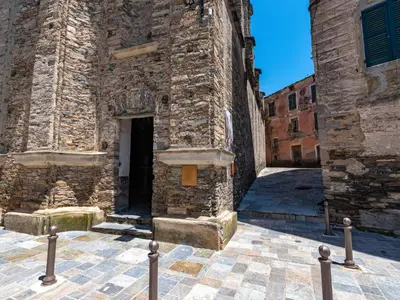 a stone building with a door in a courtyard at Holiday Home Maison Penta by Interhome in Penta-di-Casinca