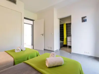 two beds in a room with green sheets and towels at Villa Villa Fautea by Interhome in Sainte-Lucie de Porto-Vecchio