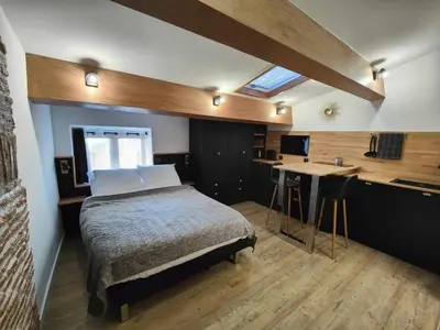 a bedroom with a bed and a desk and a kitchen at Studio rue Fesch in Ajaccio