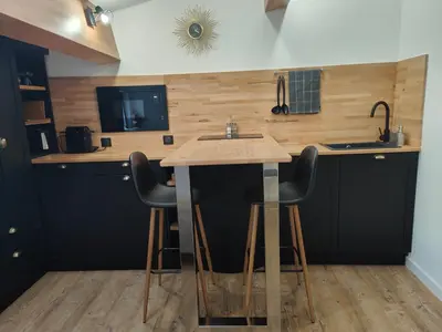 a kitchen with a counter with stools and a sink at Studio rue Fesch in Ajaccio