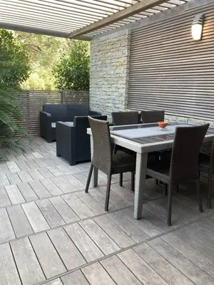 a patio with a table and chairs and a couch at Maison vue mer à 5 minutes à pied de la vieille ville de Porto Vecchio in Porto-Vecchio
