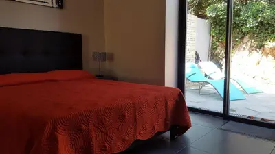 a bedroom with a bed and a sliding glass door at Maison vue mer à 5 minutes à pied de la vieille ville de Porto Vecchio in Porto-Vecchio
