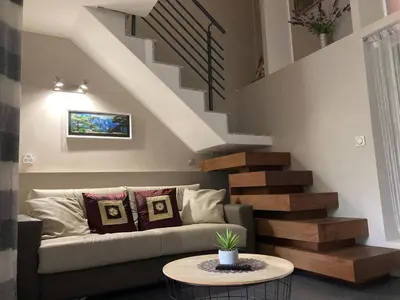 a living room with a couch and stairs at Maison vue mer à 5 minutes à pied de la vieille ville de Porto Vecchio in Porto-Vecchio