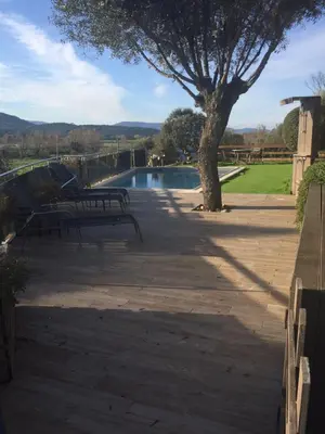 a patio with two benches and a tree next to a pool at LE PALADIN Porto Pollo Villa privée avec piscine chauffée in Serra-di-Ferro