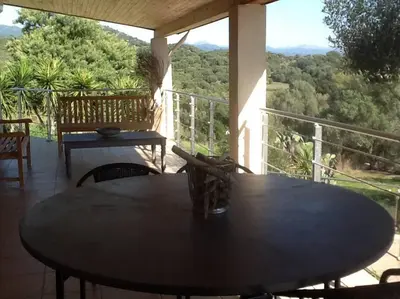 a table and chairs on a balcony with a view at LE PALADIN Porto Pollo Villa privée avec piscine chauffée in Serra-di-Ferro