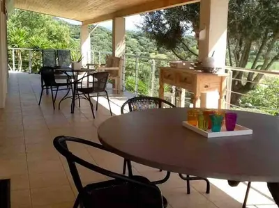 a table and chairs on a patio with a view at LE PALADIN Porto Pollo Villa privée avec piscine chauffée in Serra-di-Ferro