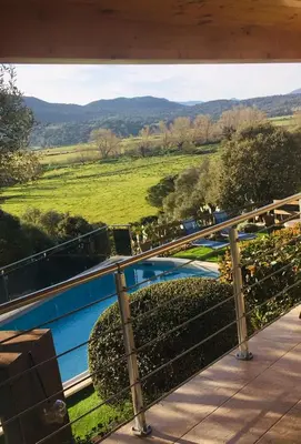 a view from the balcony of a house with horses grazing at LE PALADIN Porto Pollo Villa privée avec piscine chauffée in Serra-di-Ferro