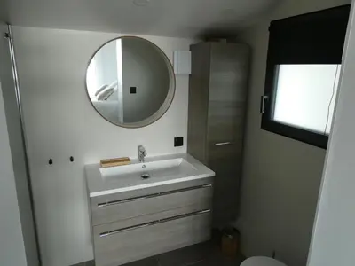 a bathroom with a sink and a mirror at Villa Corse Vue mer et piscine in Porticcio