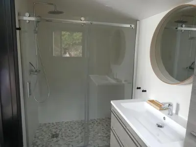 a bathroom with a shower and a sink and a mirror at Villa Corse Vue mer et piscine in Porticcio