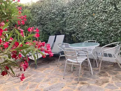 a patio with a table and chairs and flowers at Locations au centre-ville de Porto-Vecchio, jardin, terrasse, parking privé in Porto-Vecchio
