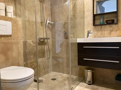 a bathroom with a shower with a toilet and a sink at Locations au centre-ville de Porto-Vecchio, jardin, terrasse, parking privé in Porto-Vecchio
