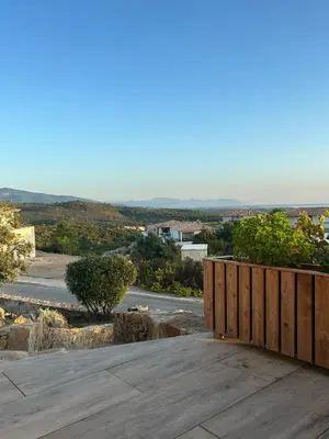 a wooden deck with a view of a road at Mini Villa vue mer in Sari Solenzara