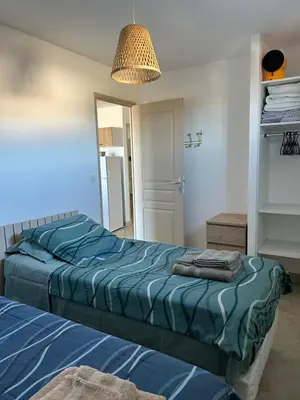 a bedroom with two beds and a mirror at Mini Villa vue mer in Sari Solenzara