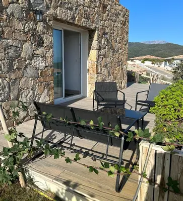 a couple of benches sitting on a patio at Mini Villa vue mer in Sari Solenzara