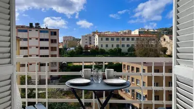 a table on a balcony with a view of a city at T2 avec balcon au coeur de Ajaccio - Clim & Wifi in Ajaccio
