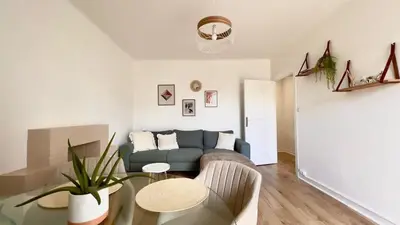 a living room with a couch and a table at T2 avec balcon au coeur de Ajaccio - Clim & Wifi in Ajaccio