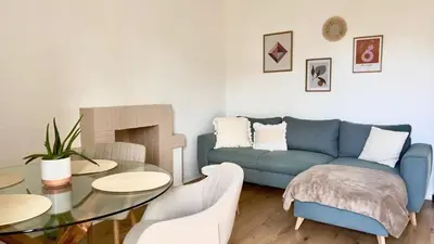 a living room with a blue couch and a table at T2 avec balcon au coeur de Ajaccio - Clim & Wifi in Ajaccio