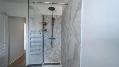 a shower with a glass door in a bathroom at T2 avec balcon au coeur de Ajaccio - Clim & Wifi in Ajaccio