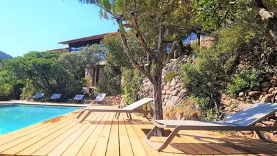 a swimming pool with two lounge chairs next to a house at maison-a-sulana-palombaggia in Porto-Vecchio