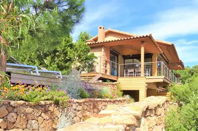 a house with a stone retaining wall and a garden at maison-a-sulana-palombaggia in Porto-Vecchio