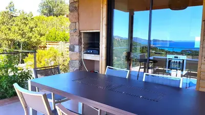 a black table and chairs on a balcony with a view at maison-a-sulana-palombaggia in Porto-Vecchio