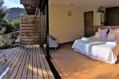 a bedroom with a bed on a wooden deck at maison-a-sulana-palombaggia in Porto-Vecchio