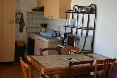 a kitchen with a wooden table and a kitchen with a microwave at Appart 5 personnes a PORTICCIO Avec 2 piscines matériel enfant ,bébé clim in Porticcio