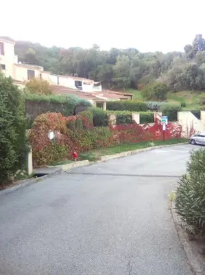 an empty street with bushes and a car on the road at Appart 5 personnes a PORTICCIO Avec 2 piscines matériel enfant ,bébé clim in Porticcio