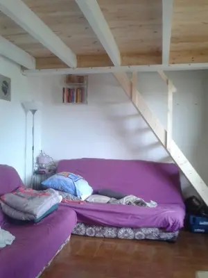 a purple couch in a room with a loft at Appart 5 personnes a PORTICCIO Avec 2 piscines matériel enfant ,bébé clim in Porticcio