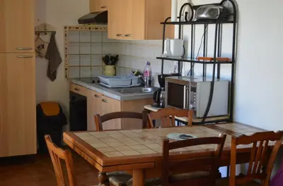 a kitchen with a wooden table with a microwave at Appart 5 personnes a PORTICCIO Avec 2 piscines matériel enfant ,bébé clim in Porticcio