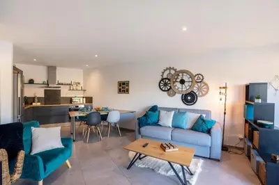 a living room with a blue couch and a table at O Ciucciarella - Appt climatisé pour 4 in Grosseto-Prugna
