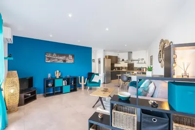 a living room with a blue accent wall at O Ciucciarella - Appt climatisé pour 4 in Grosseto-Prugna