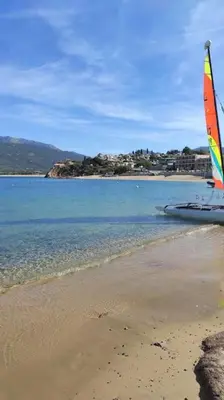 a sail boat sitting on the shore of a beach at Studio climatisée dans résidence à 5 minutes des plages a pied in Propriano